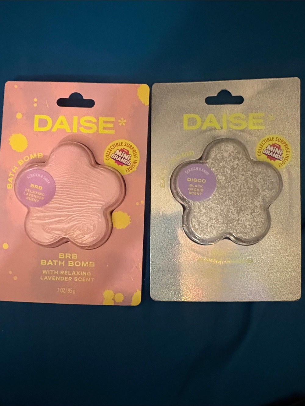 Two Daisy bath bombs with mini brand in them.
